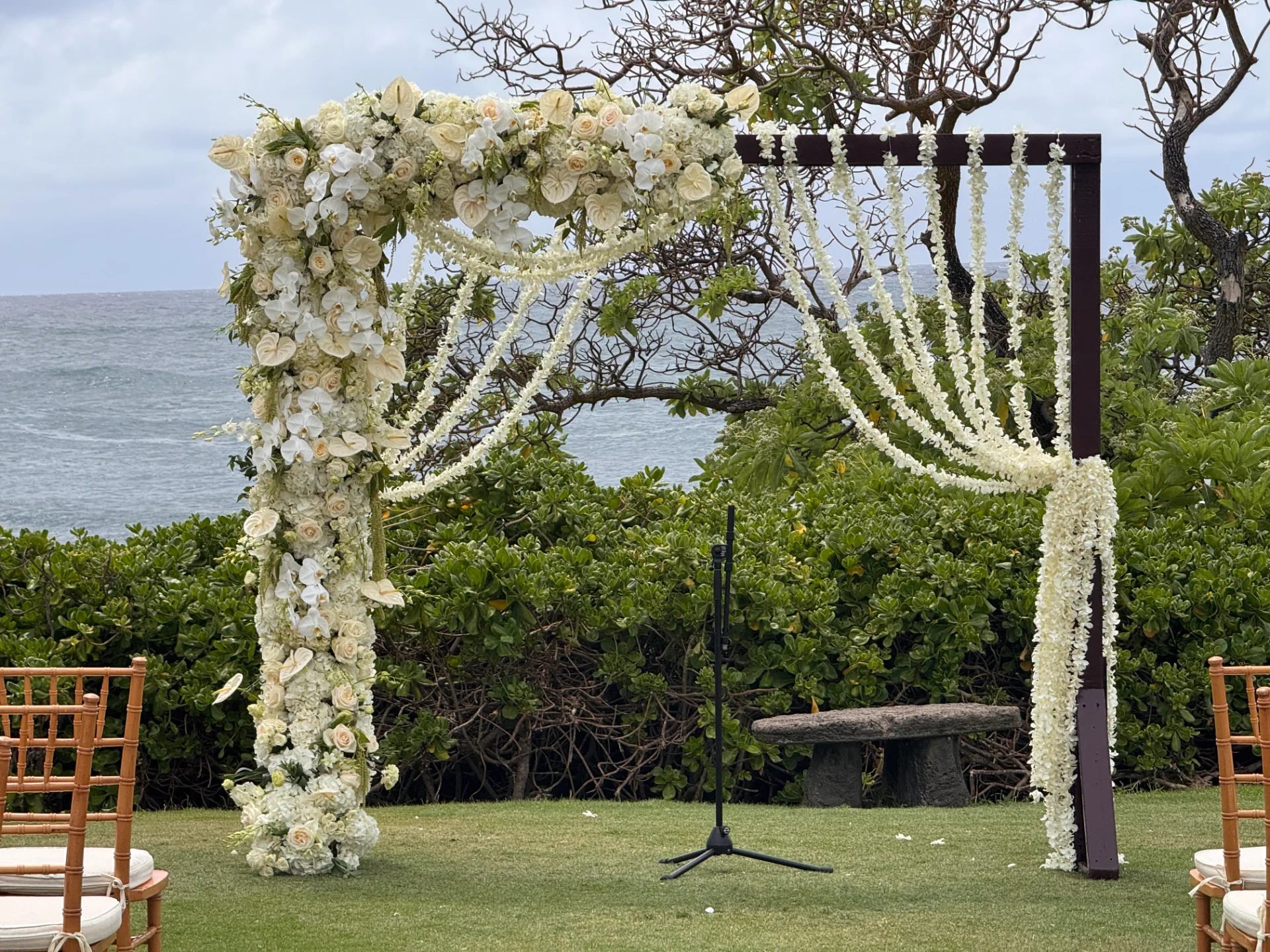 lush floral wedding arch with white roses and orchids on Oʻahu coastline