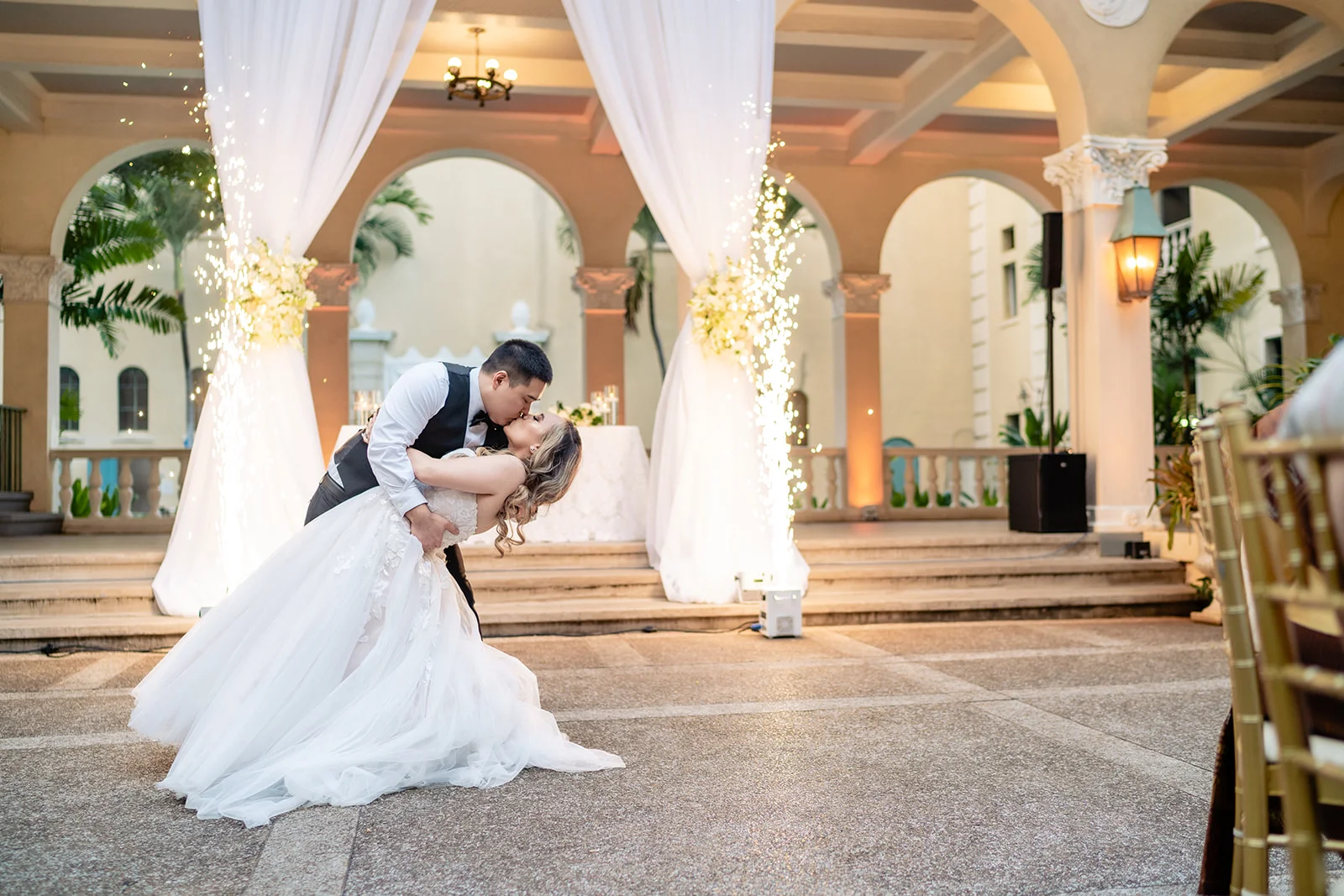 romantic couple dancing at Cafe Julia with sparklers behind and elegant wedding decor on Oʻahu