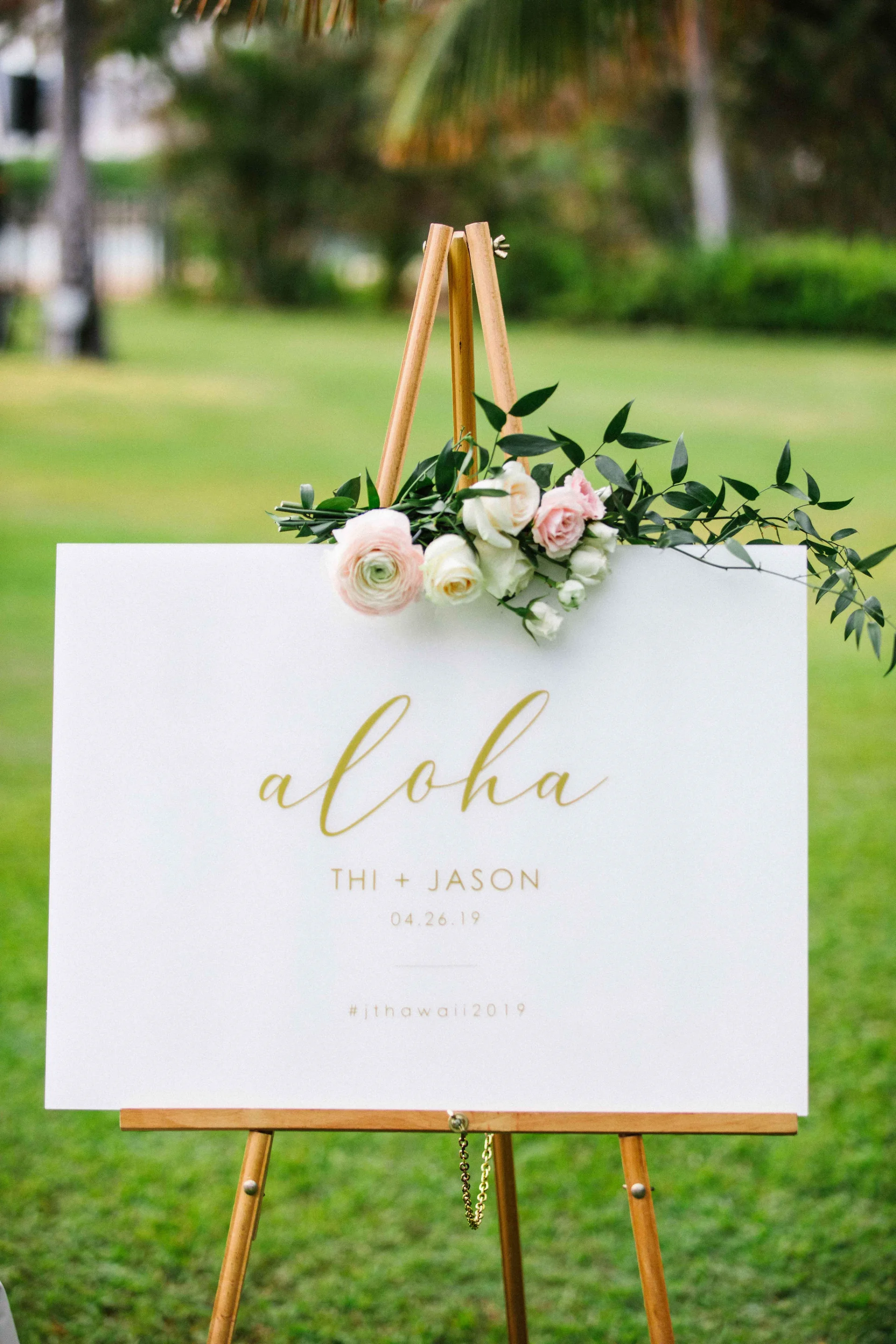 welcome sign with greenery and white roses at Lanikūhonua Cultural Institute in Oʻahu