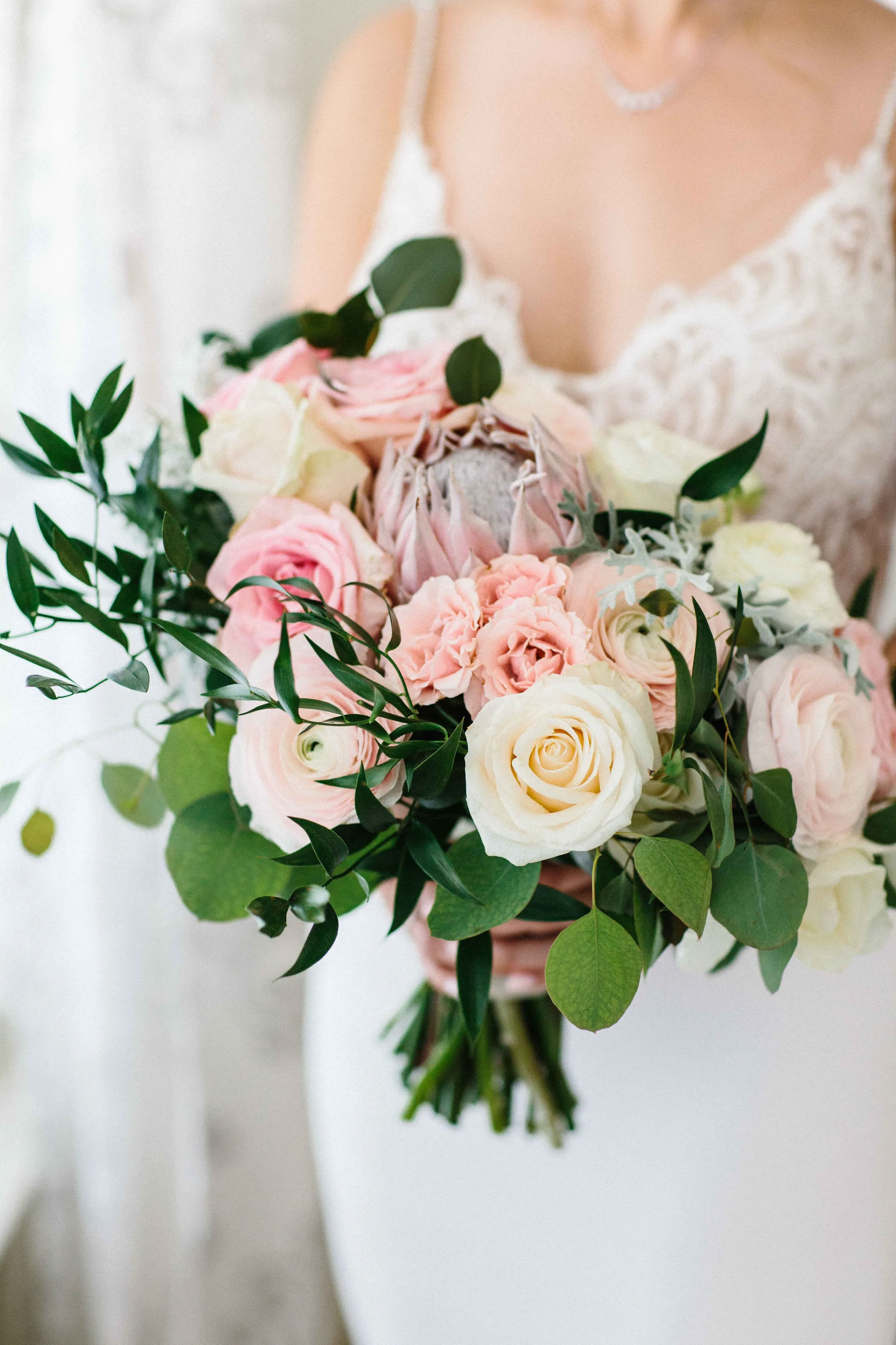 Elegant bridal bouquet with pink and white roses, protea, eucalyptus greenery at Lanikūhonua, Oʻahu wedding.